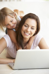 Young woman with girl using laptop computer
