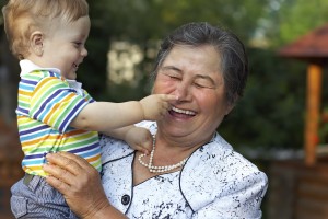 cute grandson grabbing the nose of laughing great grandmother. f
