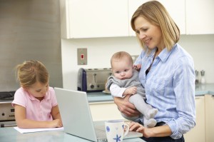 Mother with children using laptop in kitchen